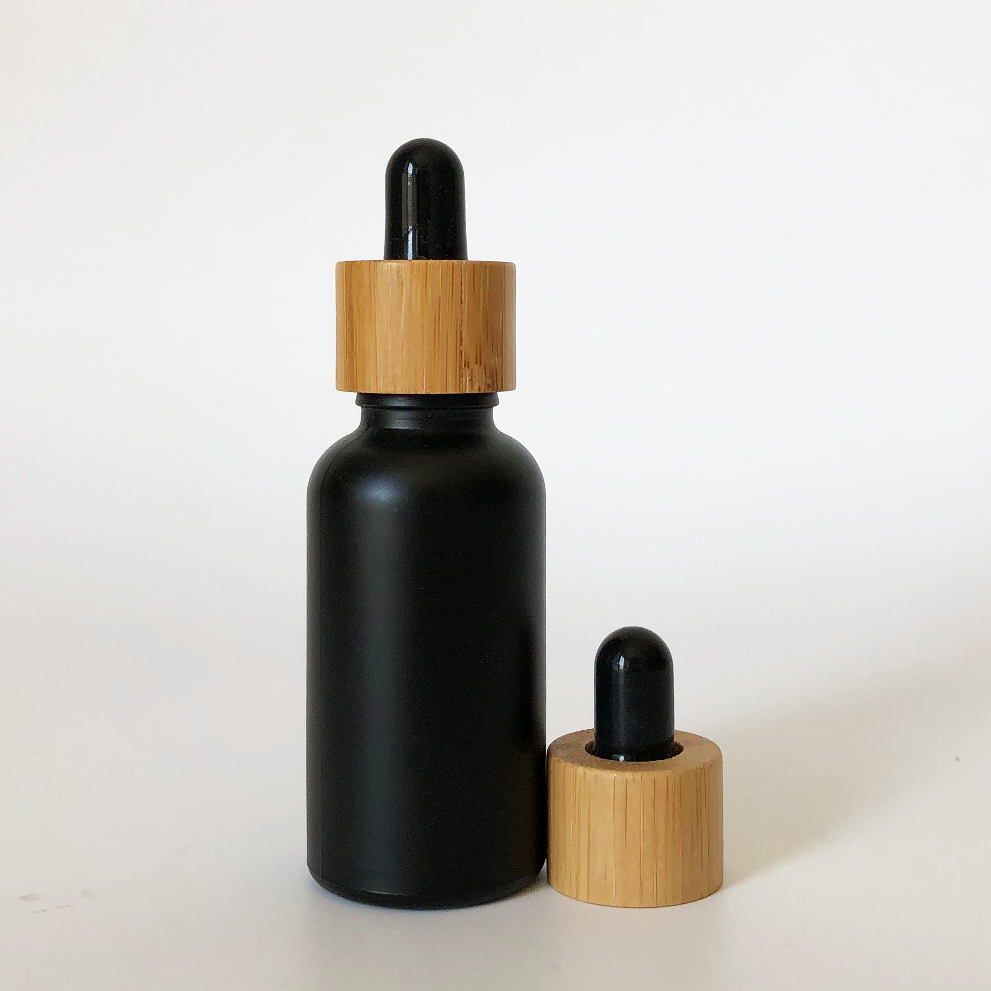 high quality 30ml black frosted glass bottle wholesale 1oz glass bottle bamboo cap