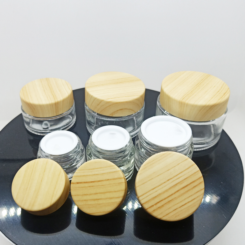 hot sale clear and frosted small glass jars for cosmetic cream with plastic cap with wood cap lid