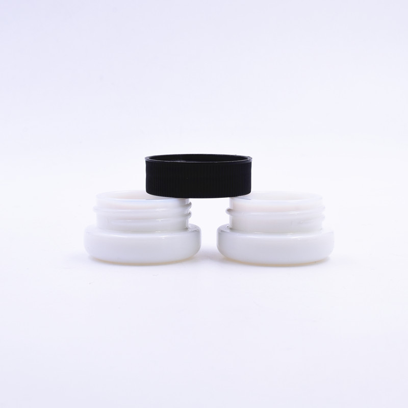 small and cute 3 ml white round  small  straight side eye cream cosmetic packing  glass jar with black  plastic child proof lid.
